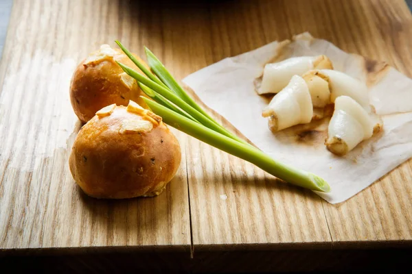 Closeup traditional ukrainian baked doughnut with garlic topping decorated with green onion and sliced tallow on wooden plate — Stock Image Closeup Traditional Ukrainian Baked Doughnut Garlic Topping Decorated Green Onion Stock Picture