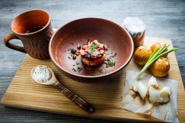 geleneksel Ukrayna plaka salata sarımsak tepesi ile pişmiş halka yanındaki yeşil soğan ile dekore edilmiş ve donyağı ahşap plaka üzerine dilimlenmiş