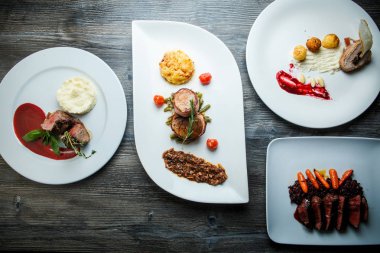 Beyaz pilakalar ve farklı yemekler et, patates püresi ve yabani pirinç Restoran koyu ahşap tablo