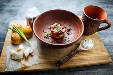 geleneksel Ukrayna plaka salata sarımsak tepesi ile pişmiş halka yanındaki yeşil soğan ile dekore edilmiş ve donyağı ahşap plaka üzerine dilimlenmiş