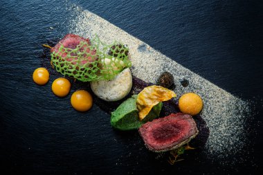 kavrulmuş et ile dekore edilmiş iki adet portre püre ve siyah plaka restoran ahşap tablo üzerinde sos