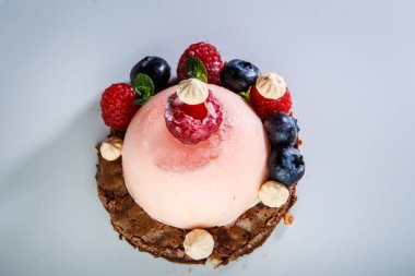 üstten görünüm üzerinde pembe tatlı taze ahududu ve beyaz arka plan beyaz plaka üzerinde yaban mersini ile kaplı