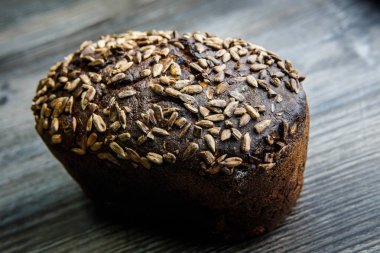 closeup bütün lezzetli el yapımı dikdörtgen çavdar ekmeği ile en iyi yalan üzerine koyu ahşap arka plan ayçiçeği tohumları