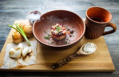 geleneksel Ukrayna plaka salata sarımsak tepesi ile pişmiş halka yanındaki yeşil soğan ile dekore edilmiş ve donyağı ahşap plaka üzerine dilimlenmiş