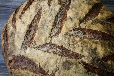 makro büyük tamamen el yapımı yuvarlak siyah ekmek ile ilginç doku yalan üzerine koyu ahşap masa