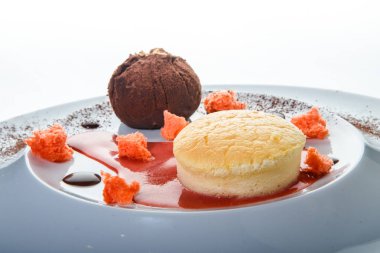 tatlı tatlı, yuvarlak küçük kek ve çikolata beyaz Restoran plaka üzerinde kırmızı vanilya sosu dekorasyonu ile