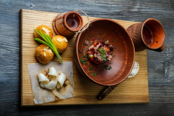 üstten görünüm geleneksel Ukrayna plaka salata sarımsak tepesi ile pişmiş halka yanındaki yeşil soğan ile dekore edilmiş ve donyağı dilimlenmiş
