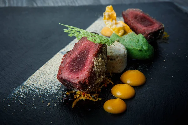 kavrulmuş et ile dekore edilmiş iki adet portre püre ve siyah plaka restoran ahşap tablo üzerinde sos