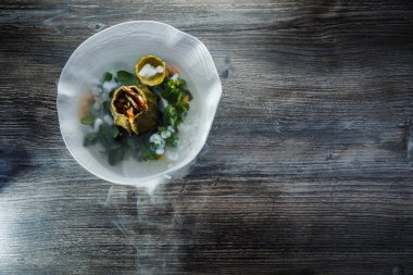 üstten görünüm üzerinde tatlı taze nane ve ahşap masa arka plan üzerinde restoran plaka üzerinde duman süslenmiş kabak servis