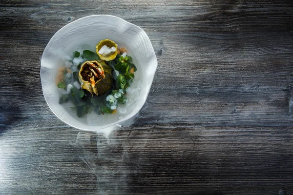 üstten görünüm üzerinde tatlı taze nane ve ahşap masa arka plan üzerinde restoran plaka üzerinde duman süslenmiş kabak servis