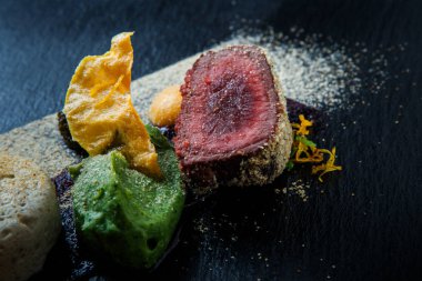 makro iki adet kavrulmuş et ile dekore edilmiş püresi ve siyah plaka restoran ahşap tablo üzerinde sos