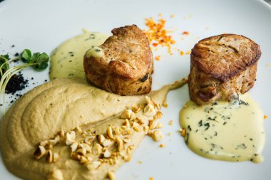 makro iki lezzetli adet ızgara et püresi ve ahşap masa arka plan üzerinde beyaz Restoran tabakta sos ile