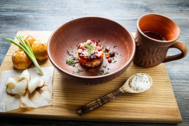 geleneksel Ukrayna plaka salata sarımsak tepesi ile pişmiş halka yanındaki yeşil soğan ile dekore edilmiş ve donyağı ahşap plaka üzerine dilimlenmiş