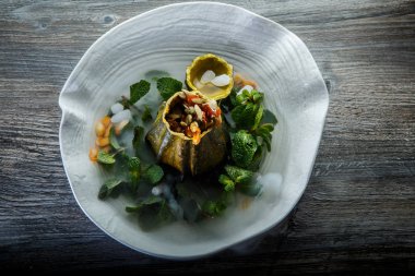 üstten görünüm üzerinde tatlı taze nane ve ahşap masa arka plan üzerinde restoran plaka üzerinde duman süslenmiş kabak servis