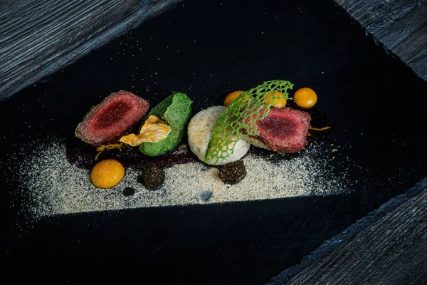 kavrulmuş et ile dekore edilmiş iki adet püresi ve siyah plaka restoran ahşap tablo üzerinde sos