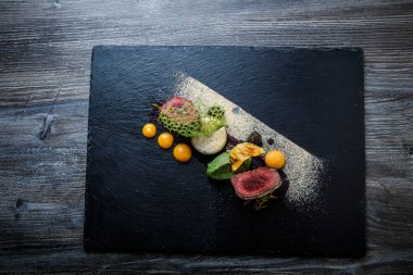 üstten görünüm üzerinde iki adet kavrulmuş et püresi ve siyah plaka restoran ahşap tablo üzerinde sos ile dekore edilmiş