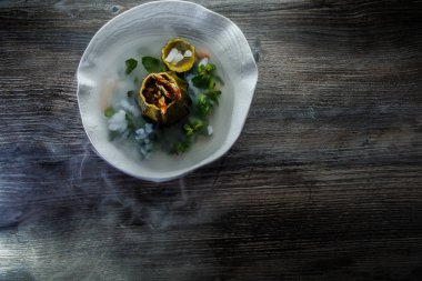 üstten görünüm üzerinde tatlı taze nane ve ahşap masa arka plan üzerinde restoran plaka üzerinde duman süslenmiş kabak servis