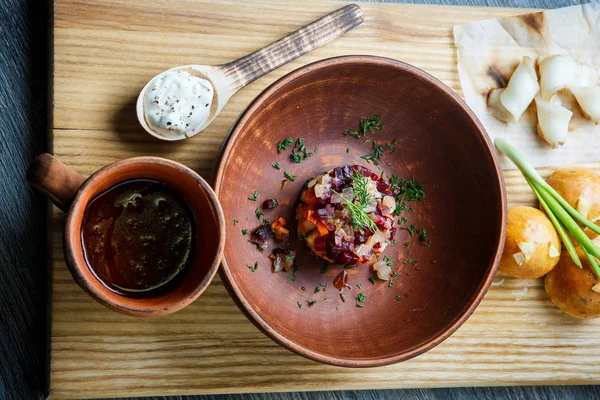 üstten görünüm geleneksel Ukrayna plaka salata sarımsak tepesi ile pişmiş halka yanındaki yeşil soğan ile dekore edilmiş ve donyağı dilimlenmiş