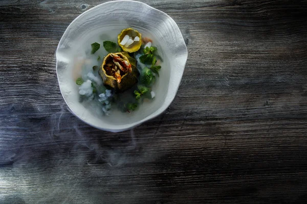 üstten görünüm üzerinde tatlı taze nane ve ahşap masa arka plan üzerinde restoran plaka üzerinde duman süslenmiş kabak servis