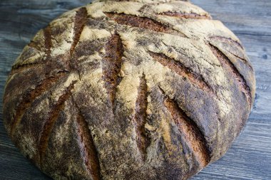 büyük tamamen el yapımı yuvarlak siyah ekmek üzerinde koyu ahşap masa ilginç doku yalanla