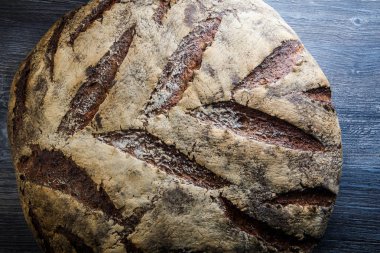 makro büyük tamamen el yapımı yuvarlak siyah ekmek ile ilginç doku yalan üzerine koyu ahşap masa
