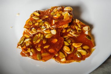 ahşap masa arka plan üzerinde beyaz tabakta servis karamelize şeker tatlı tatlı Kabak tohumları