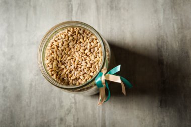 Üstten Görünüm açılan cam buğday tohumu beyaz ile dekore edilmiş ve mavi kurdele mutfak masasının üstünde duran