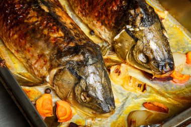 kafa ile kavrulmuş bütün doldurulmuş balık havuç, pancar ve soğan ile servis parçaları metal denemede