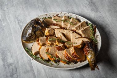 otlar ile dekore edilmiş dilimlenmiş kavrulmuş doldurulmuş balık ile beyaz Restoran plaka servis