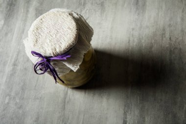 Yukarıdan küçük kavanoz kaplı ile el yapımı doku ve mor kurdele stand gri masaya