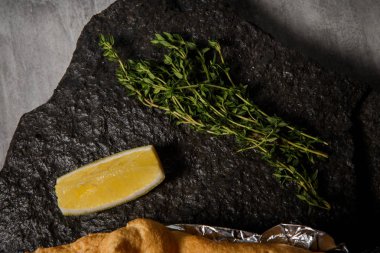 çırpılmış yumurta akı ile dilimlenmiş limon ve biberiye siyah Restoran tablet gri masada servis altında dorado closeup pişmiş