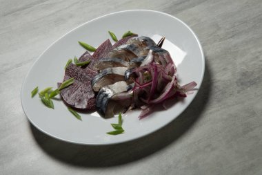 uskumru ve pancar dilimleri gri masada beyaz Restoran tabakta servis doğranmış kırmızı ve yeşil soğan ile