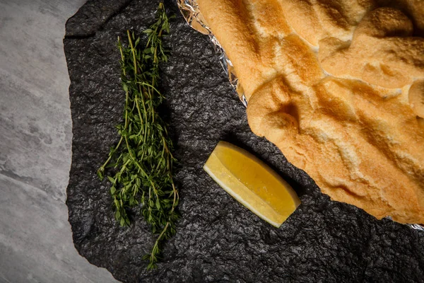 çırpılmış yumurta akı ile dilimlenmiş limon ve biberiye siyah Restoran tablet gri masada servis altında dorado closeup pişmiş