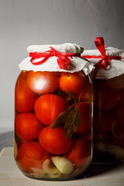 closeup iki büyük cam kavanoz ile ev yapımı domates stand mutfak masasında gri duvar arka plan karşı konserve