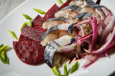 uskumru ve pancar dilimleri gri masada beyaz Restoran tabakta servis doğranmış kırmızı ve yeşil soğan ile