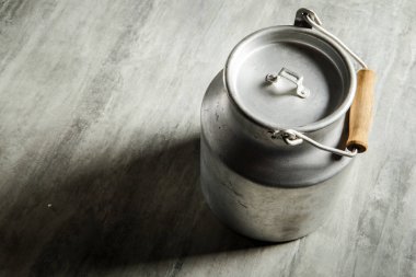 üst görüntülemek eski alüminyum bidon süt depolama için ahşap saplı tür gri arka plan üzerinde