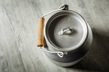 closeup üst görüntülemek eski alüminyum bidon süt depolama için ahşap saplı tür gri arka plan üzerinde