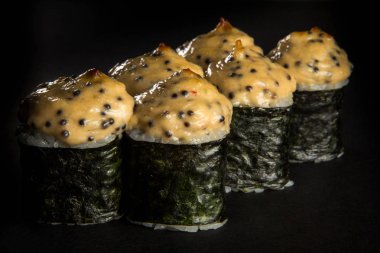 rulo ile somon füme, salatalık, siyah arka plan üzerine hizmet peynir sos ile dekore edilmiş philadelphia krem peynir pişmiş tatlı