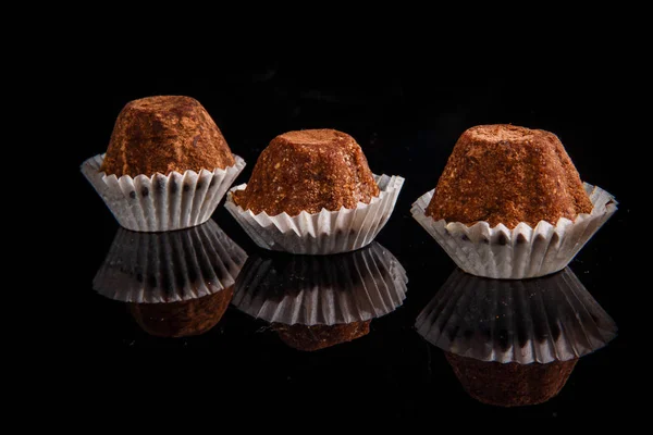 健康の有用な有機の手作りチョコレート菓子の行は飾らブラック ミラーの背景に茶色のココア パウダー — ストック写真