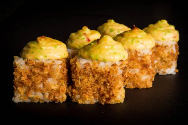 portre rulo ile füme tavuk, tobiko havyar, üstte siyah arka plan üzerine hizmet kranch-soğan ve peynir soslu krem peynir dekore philadelphia pişmiş.