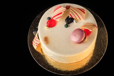 üstten görünüm lezzetli yuvarlak kek çikolata renkli, mor acıbadem kurabiyesi ile dekore edilmiş beyaz sır ve siyah arka plan üzerine hizmet marmelat