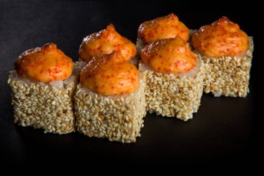 fırında üstten görünüm portre rulo mantar, domates, krem peynir dekore nori, peynir sos ve tobiko ile philadelphia üstüne havyar servis siyah arka plan üzerine