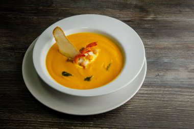 sarı balık dekore edilmiş karides kuyrukları ve bir dilim kuru ekmek çorbası Krem