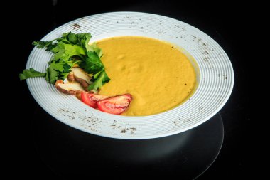 Sarı mantar kremalı çorba mantar, domates ve maydanoz ile süslenmiş