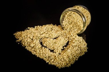 küçük cam kavanozdan dışarı dökülür yeşil organik deniz tuzu closeup kalp boyalı