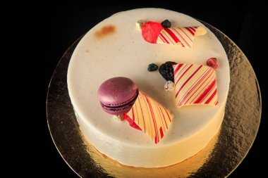 lezzetli yuvarlak pasta beyaz sır ile mor macaron ile dekore edilmiştir.