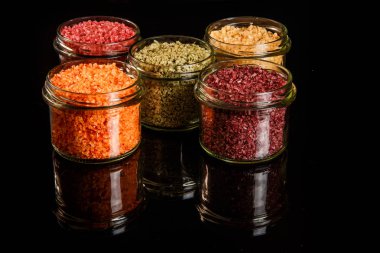 beş küçük cam kavanoz farklı renklerde deniz tuzu ile dolu