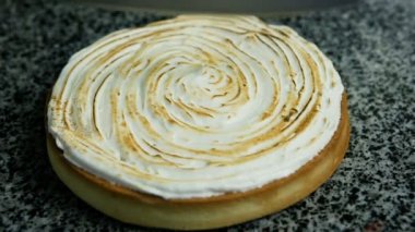 insan eli yarım ev yapımı limonlu pasta kesme bıçak, masada beyaz köpük krema ile dekore edilmiş olan