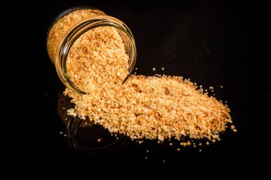 büyük sarı organik deniz tuzu küçük cam kavanozdan dışarı dökülür