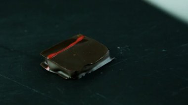 küçük kare çikolata şeker Karamel dolgulu bıçak, siyah mutfak masasında ikiye böldüm
